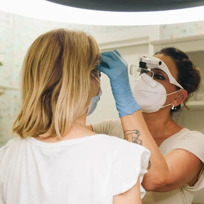 Profesional realizando un estudio de visagismo de cejas